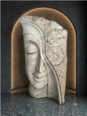 Marble Buddha face emerging from a split stone block